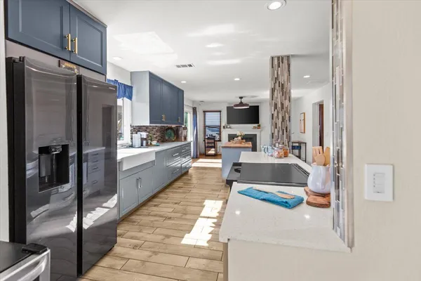 a large kitchen with a large counter top stainless steel appliances and cabinets
