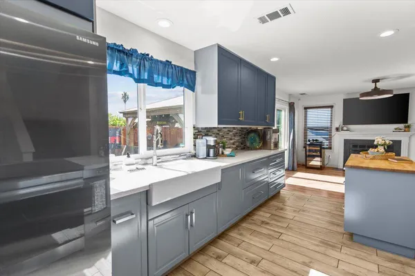 a large kitchen with stainless steel appliances wooden floor and a counter top space