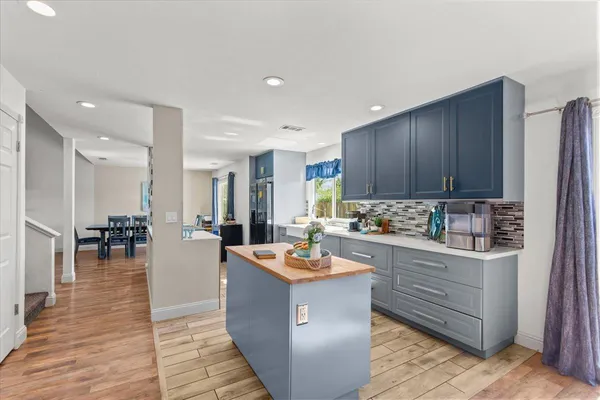 a kitchen with granite countertop cabinets a dining table and chairs