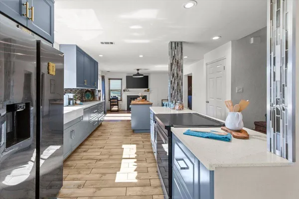 a kitchen with stainless steel appliances granite countertop a refrigerator a stove and a sink