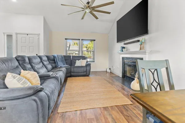 a living room with furniture a flat screen tv and a fireplace
