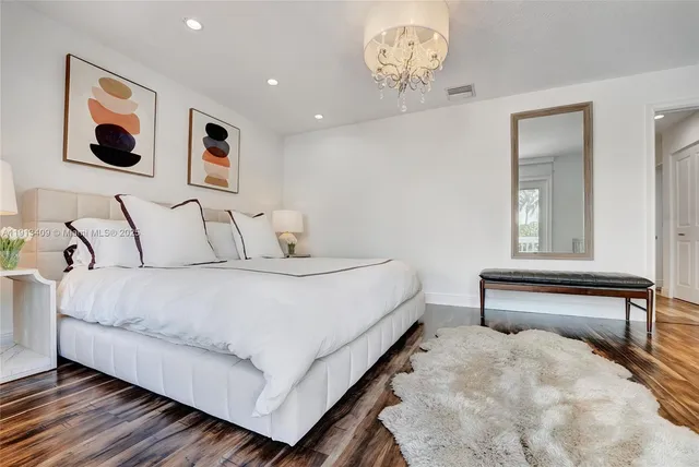 a bedroom with a bed and a painting on the wall