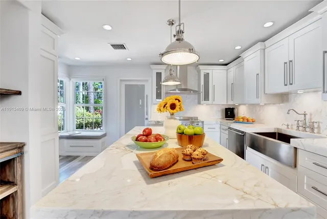 a kitchen with stainless steel appliances kitchen island granite countertop a sink and cabinets