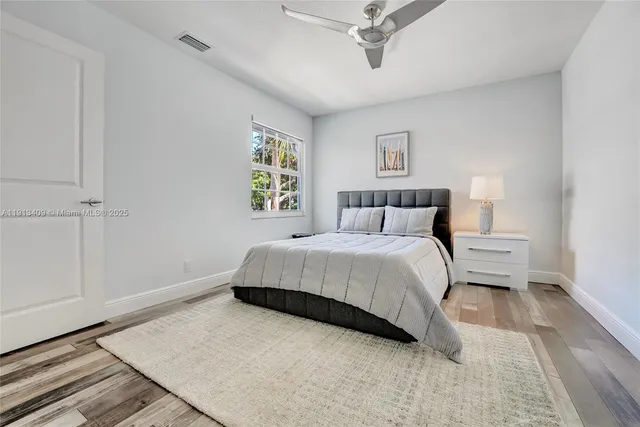 a bedroom with a bed and painting on the wall