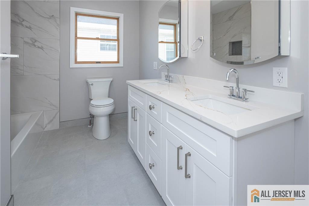 278 Rector Street Perth Amboy, NJ 08861 - Photo 26 of 47 a spacious bathroom with 2 sink toilet and a mirror