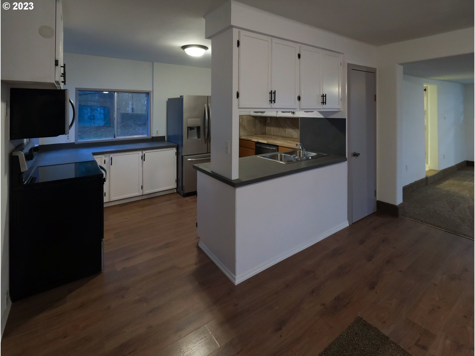 122 Talbott Road Salkum, WA 98582 - Photo 18 of 32 a kitchen with stainless steel appliances a stove a refrigerator a sink and white cabinets with wooden floor