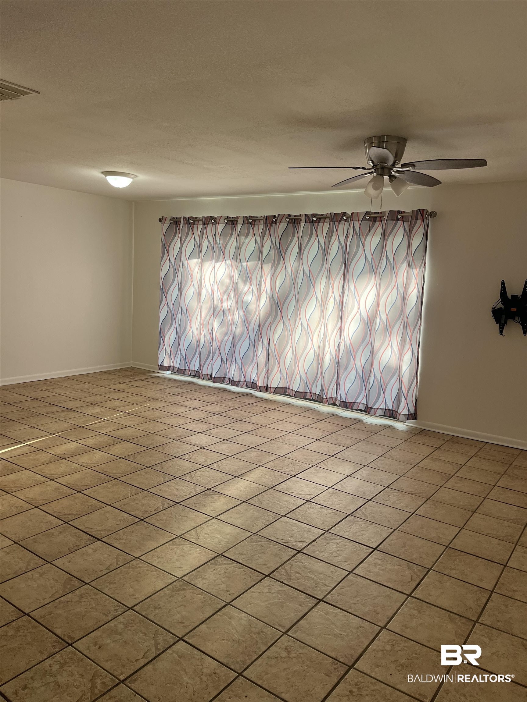 1146 North Alston Street Foley, AL 36535 - Photo 6 of 20 Tiled empty room with a ceiling fan and baseboards