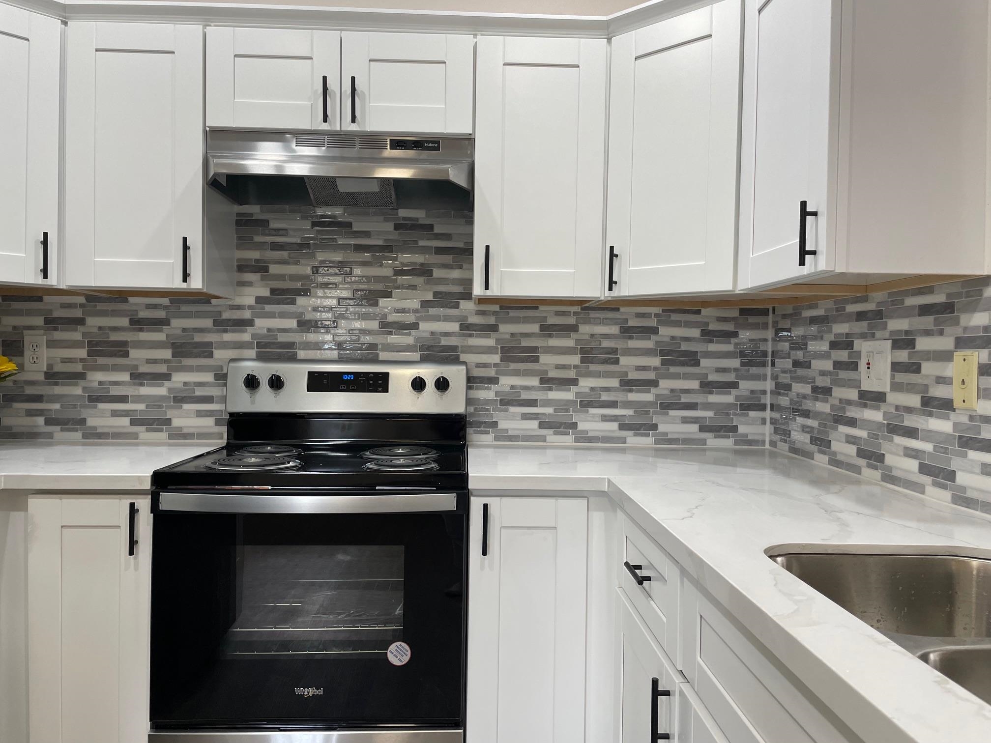 a kitchen with granite countertop a stove sink and cabinets