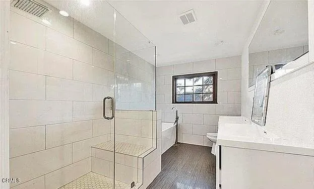 a bathroom with a sink a toilet and shower