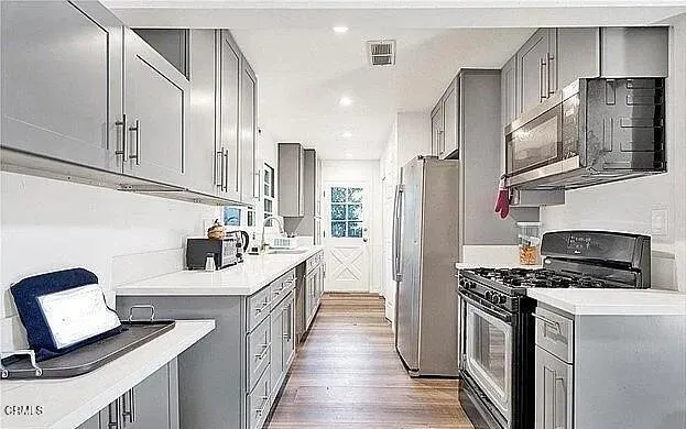 a kitchen with stainless steel appliances a refrigerator sink and stove