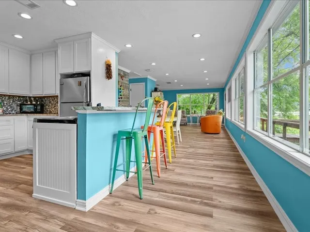 a kitchen with stainless steel appliances kitchen island granite countertop a refrigerator and a sink