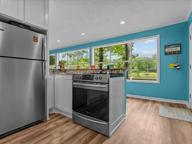 a kitchen with a stove a refrigerator and a wooden floor