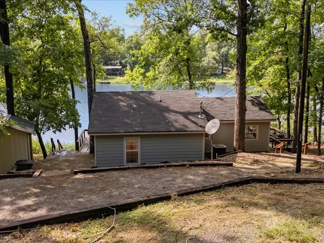 a view of a house with a yard and large tree
