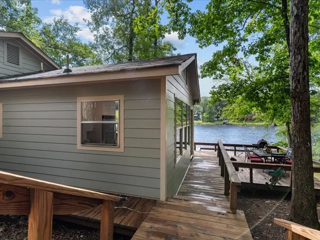 a view of a patio with table and chairs with wooden floor and fence