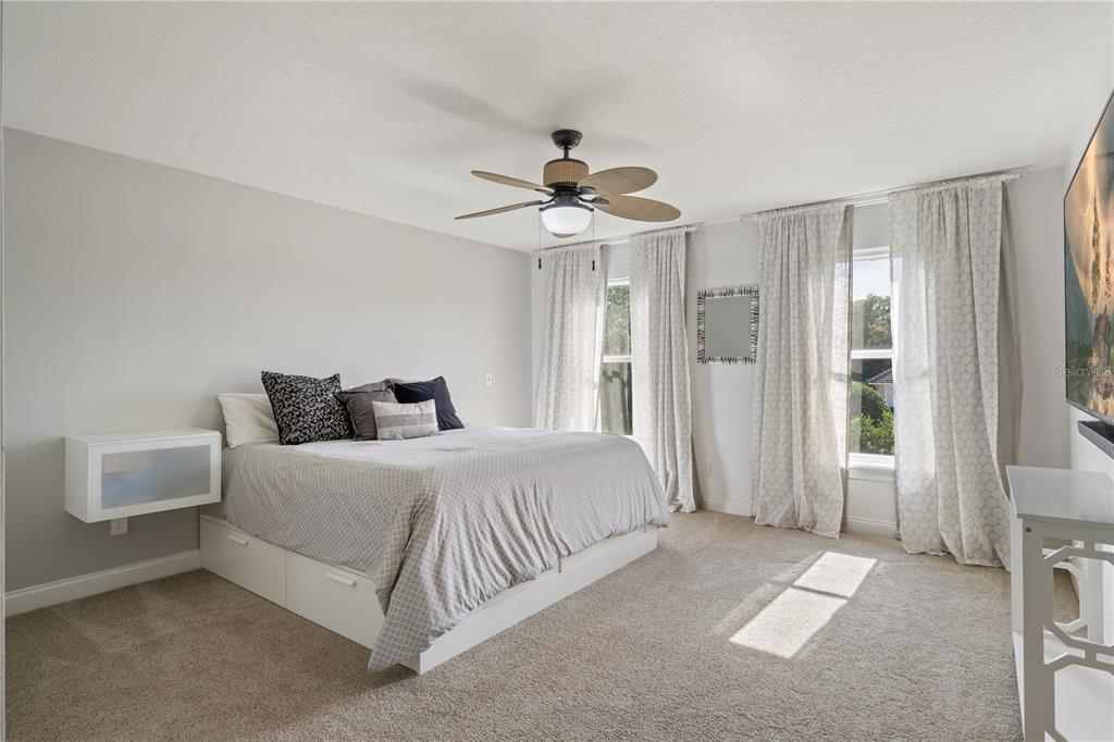 2002 Water Key Drive Windermere, FL 34786 - Photo 28 of 60 a spacious bedroom with a bed and a chandelier