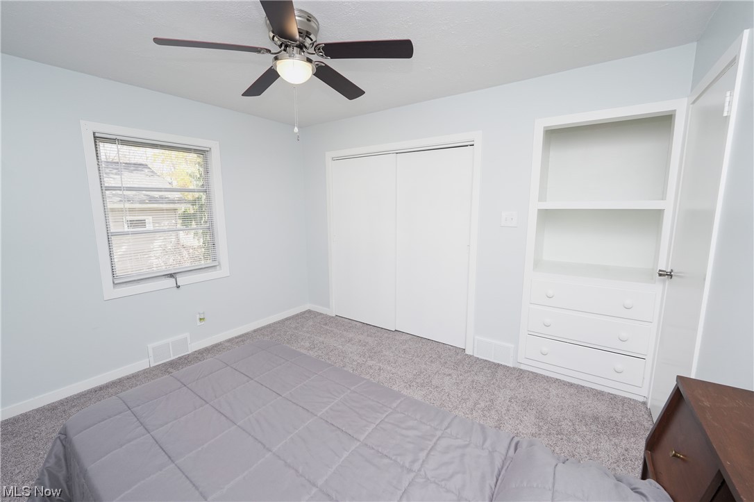 601 Shook Road Akron, OH 44319 - Photo 18 of 35 Unfurnished bedroom with ceiling fan, a closet, and light carpet