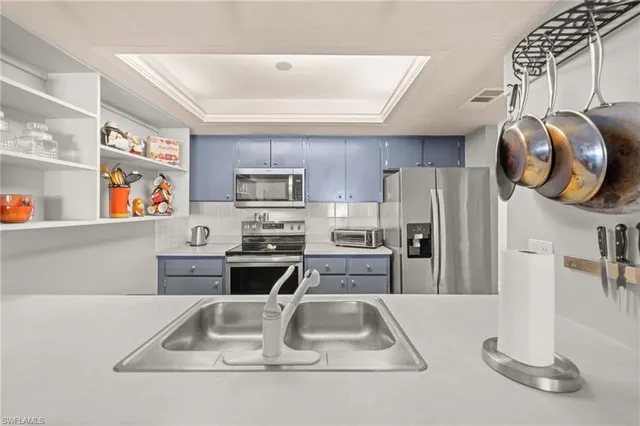 a kitchen with stainless steel appliances granite countertop a sink and a refrigerator