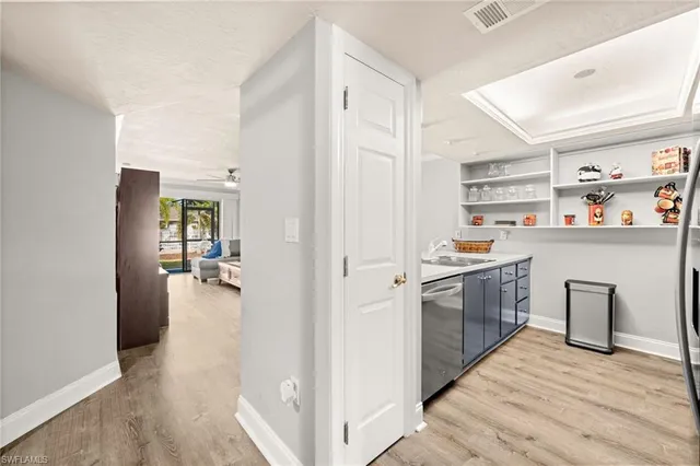 a kitchen with a refrigerator and wooden floor