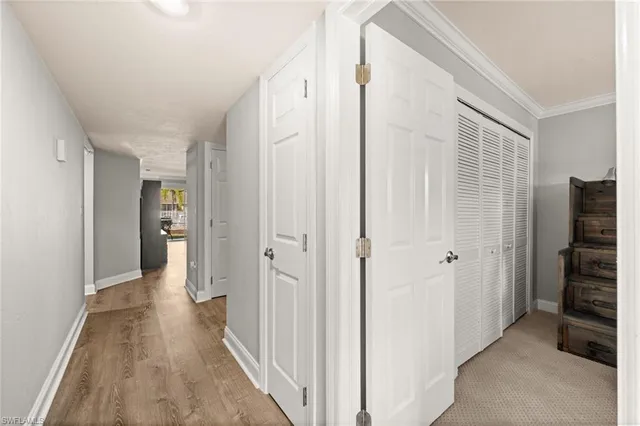 a view of a hallway with wooden floor and closet area