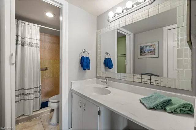 a bathroom with a granite countertop sink a toilet and shower