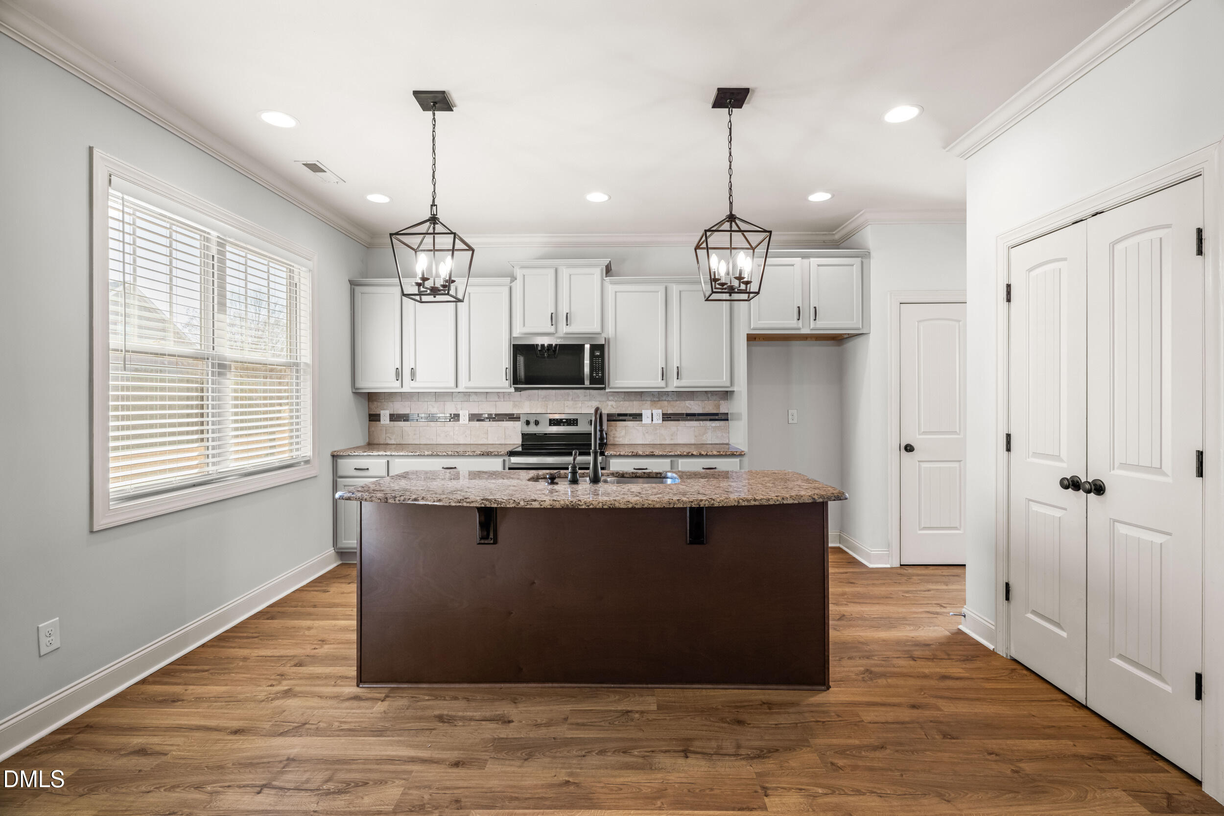 86 Sharpstone Lane Clayton, NC 27527 - Photo 11 of 36 a view of kitchen with kitchen island stainless steel appliances wooden floor and window