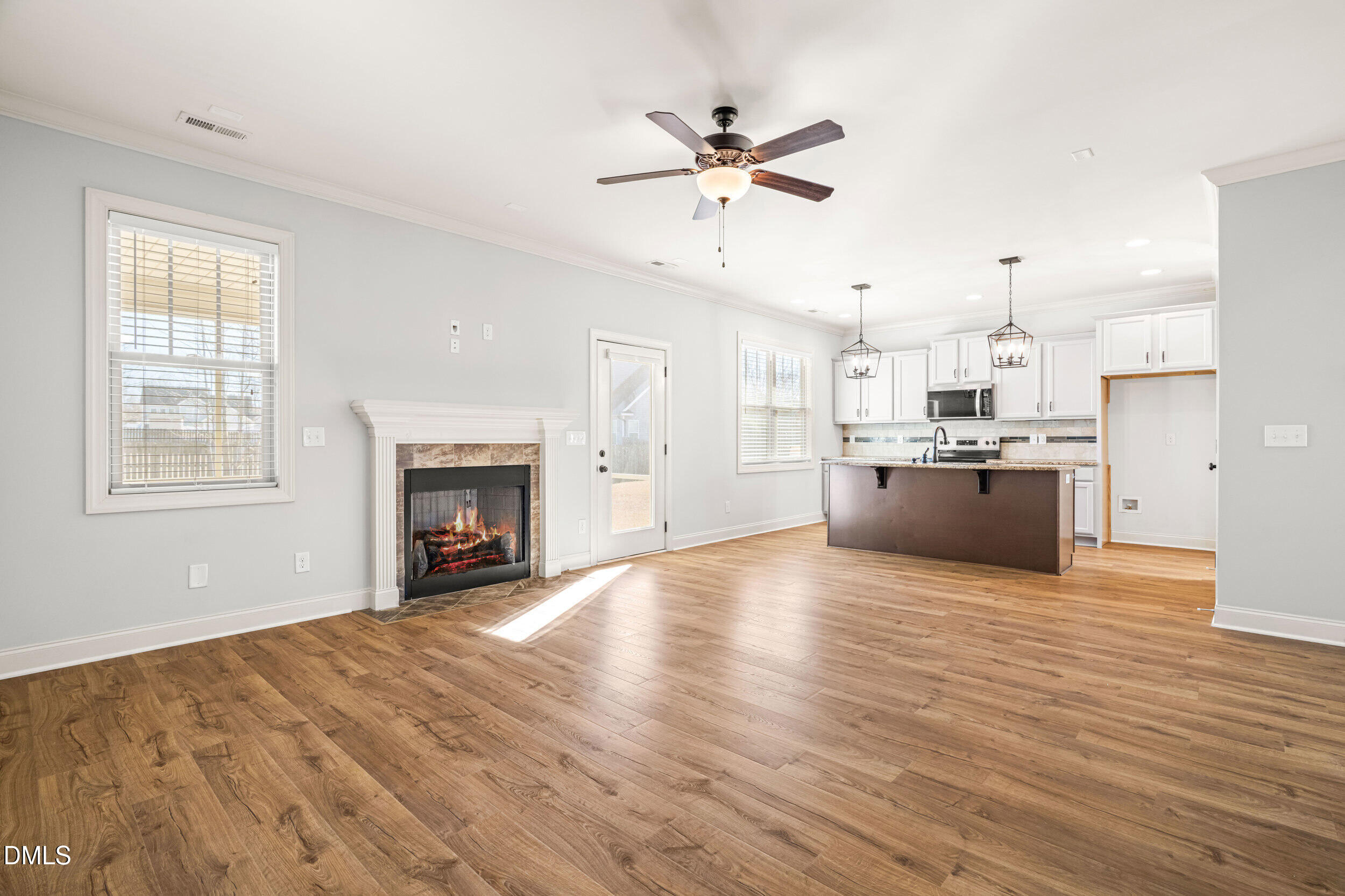 86 Sharpstone Lane Clayton, NC 27527 - Photo 13 of 36 a view of a kitchen with a stove cabinets wooden floor and a ceiling fan
