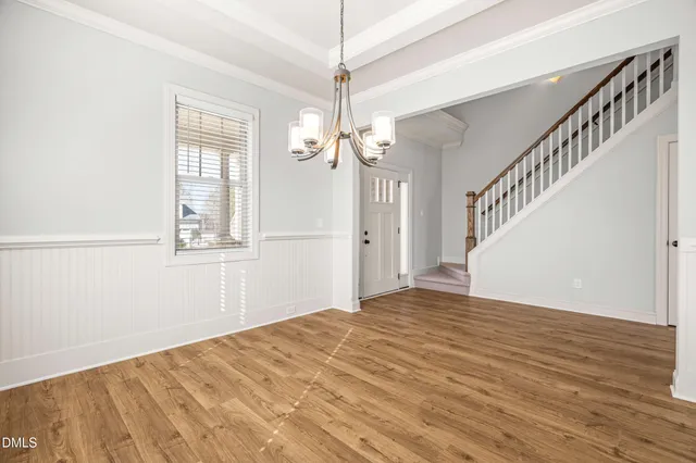 a kitchen with a sink chandelier and wooden floor