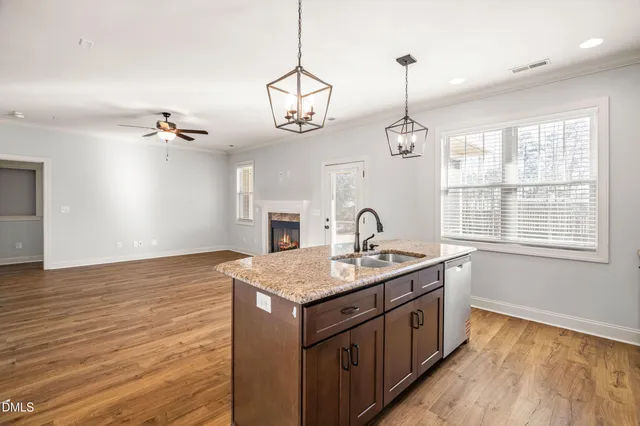 a view of a kitchen with a stove cabinets wooden floor and a ceiling fan