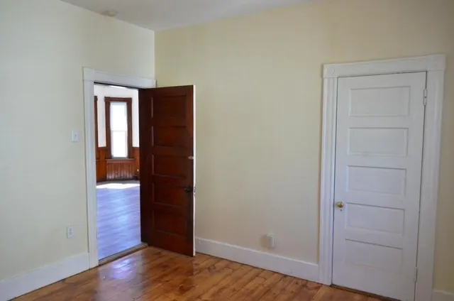 a view of a small space with wooden floor and a window