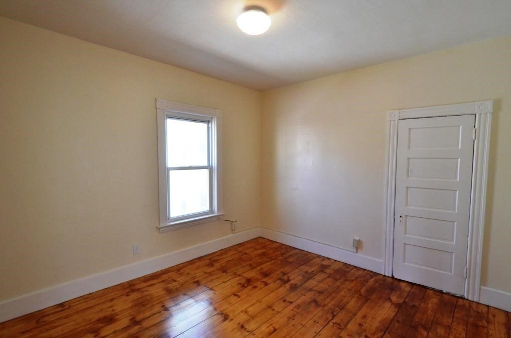 71 Esther Street, Unit 2 Worcester, MA 01607 - Photo 15 of 19 an empty room with wooden floor and windows