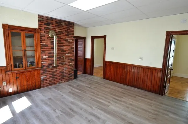 a view of an empty room with wooden floor and stairs