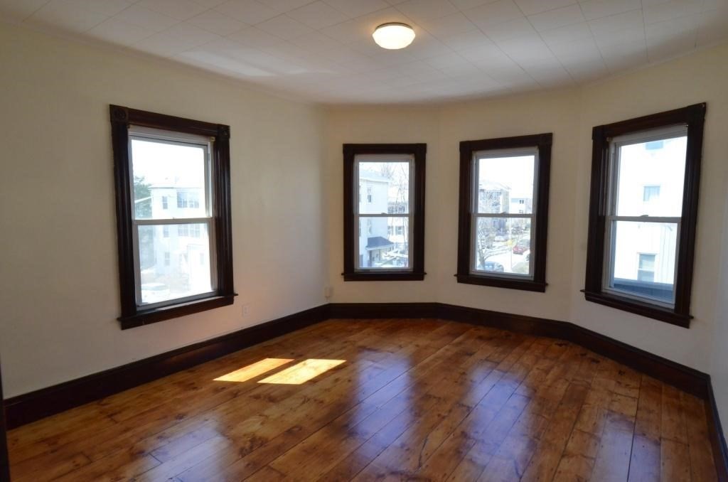 71 Esther Street, Unit 2 Worcester, MA 01607 - Photo 8 of 19 a view of an empty room with wooden floor and a window