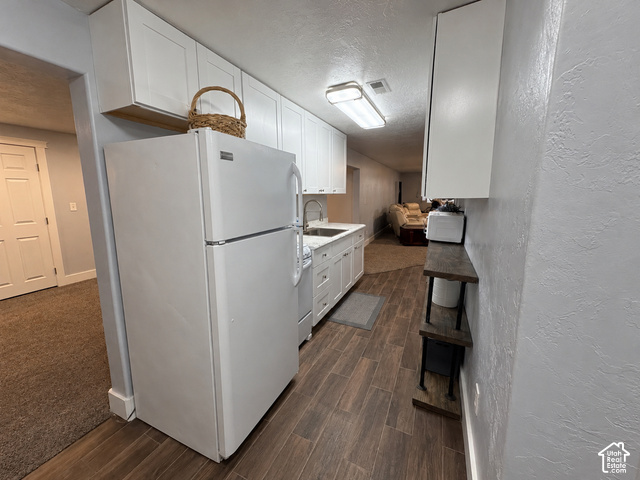 1750 West 4100 North Helper, UT 84526 - Photo 39 of 50 Galley-style kitchen featuring white cabinetry, stainless steel appliances including a refrigerator and electric range, wood-finish flooring, and recessed ceiling lighting