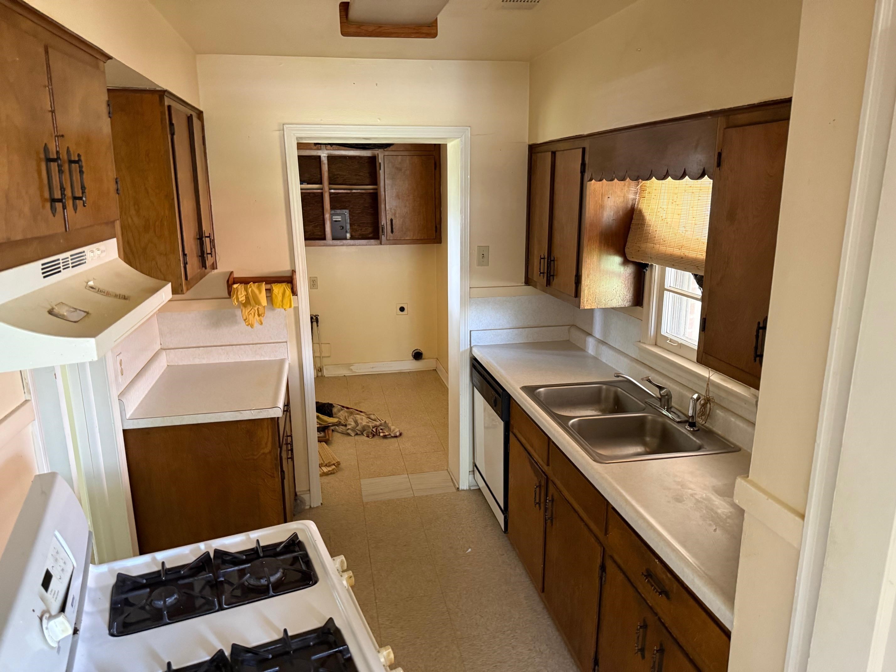 4519 Quince Road Memphis, TN 38117 - Photo 7 of 7 Kitchen featuring a sink, white appliances, light countertops, and brown cabinetry