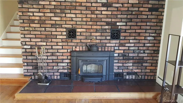 a view of empty room with wooden floor and fireplace
