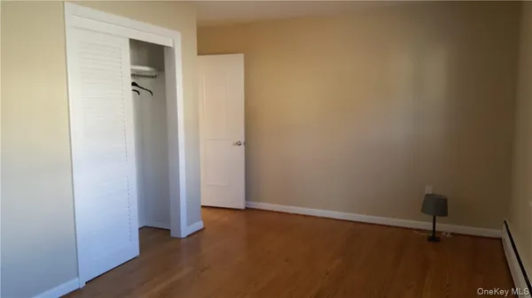 a view of a room with wooden floor and a window
