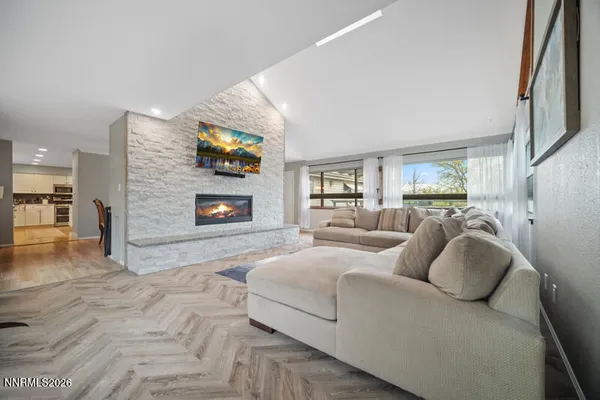 a kitchen with stainless steel appliances granite countertop a stove a sink a microwave a refrigerator and white cabinets with wooden floor