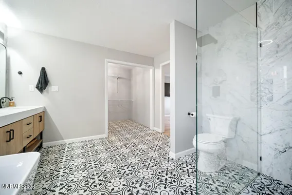 a bathroom with a double vanity sink toilet mirror and window