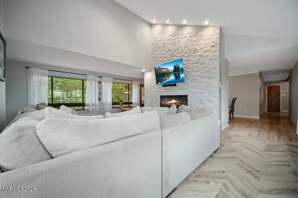 a dining room with furniture a chandelier and wooden floor