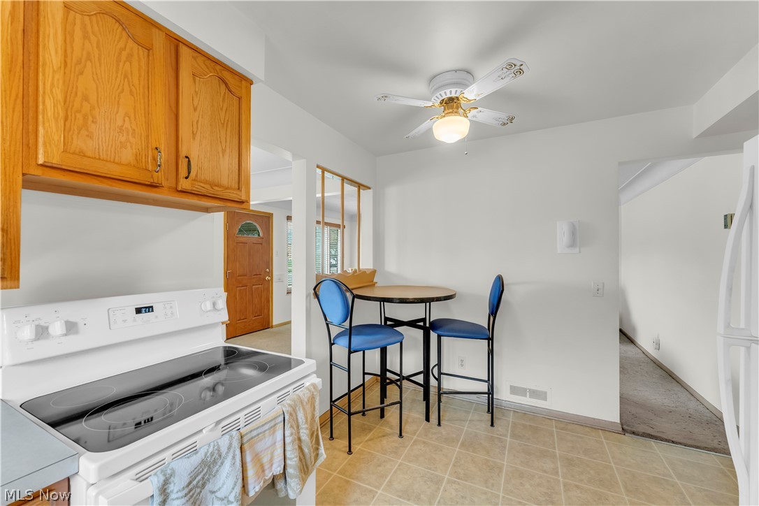 3023 Norris Avenue Cleveland, OH 44134 - Photo 16 of 41 Kitchen featuring a white electric range, wood cabinetry, and a ceiling fan with light