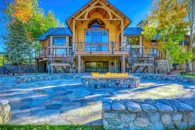 a view of an ocean with a floor to ceiling window next to a yard