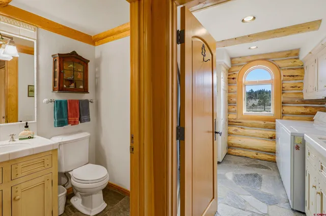 a bathroom with a granite countertop toilet sink and mirror