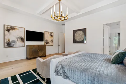 a spacious bedroom with a bed and a chandelier