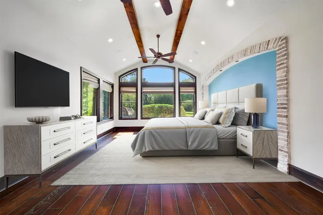 a bedroom with a large bed and flat screen tv