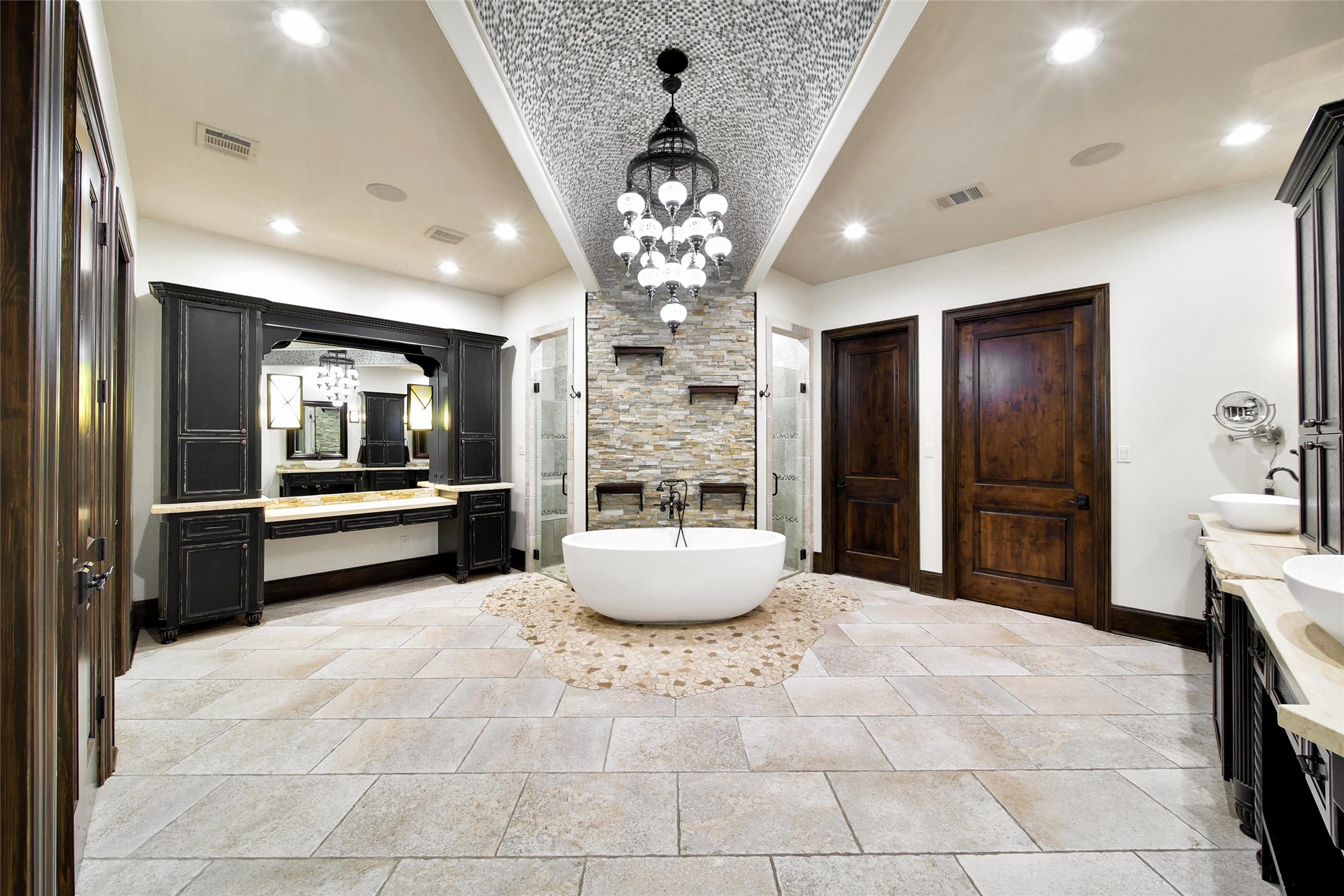 2 Highclere Park Drive Spring, TX 77379 - Photo 20 of 50 This opulent en-suite bath offers the ultimate in comfort and elegance. Featuring dual sinks, a deep soaking tub, a spacious walk-through shower, and a dedicated make-up vanity. Enjoy the convenience of two private water closets and double walk-in closets with custom built-in, floor to ceiling storage solutions.