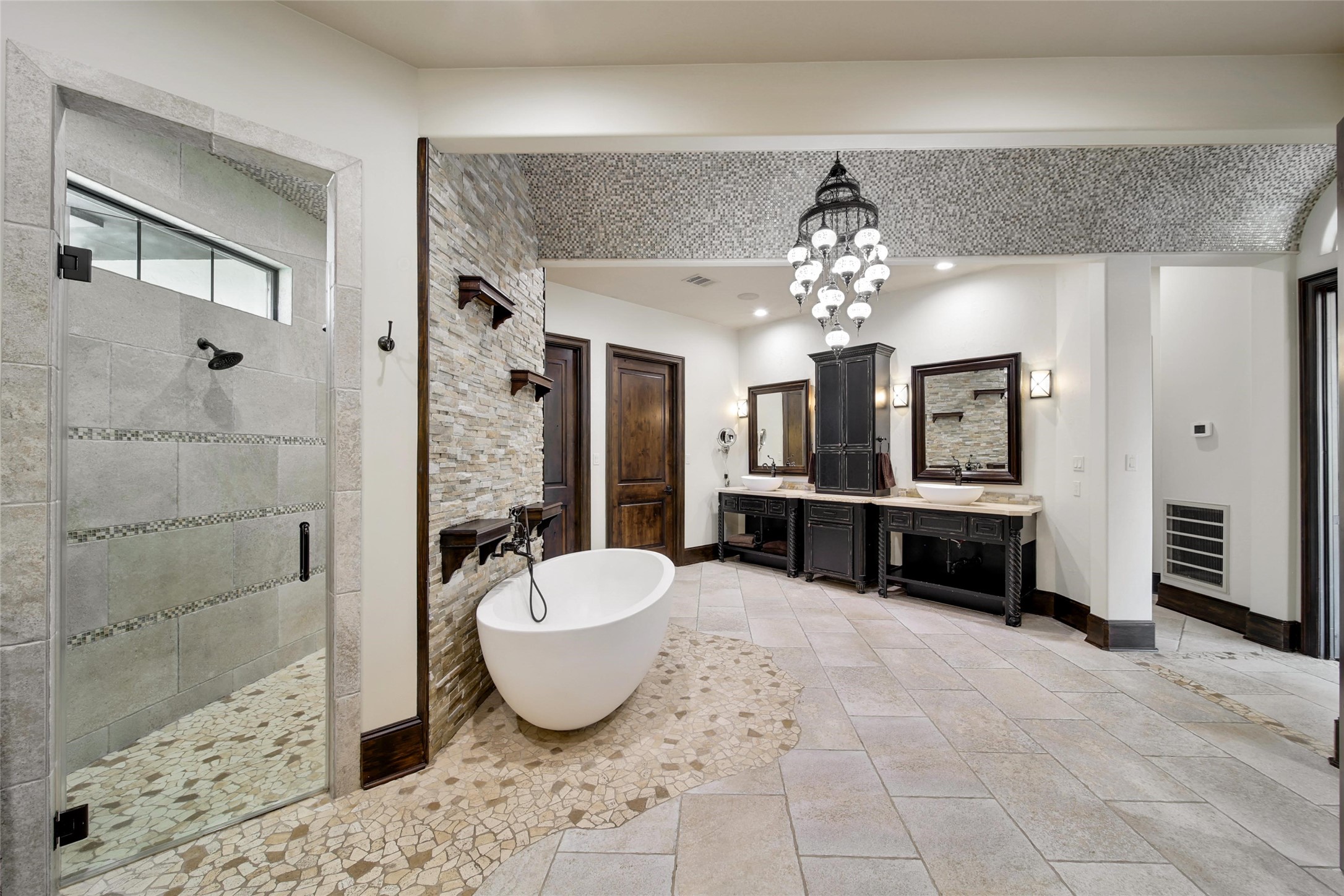 2 Highclere Park Drive Spring, TX 77379 - Photo 21 of 50 A refined, spa-like retreat with elegant details throughout. Features include a walk-through shower, freestanding tub, barreled ceiling with chandelier, and a built-in TV cabinet with a coffee or wine bar for added comfort.