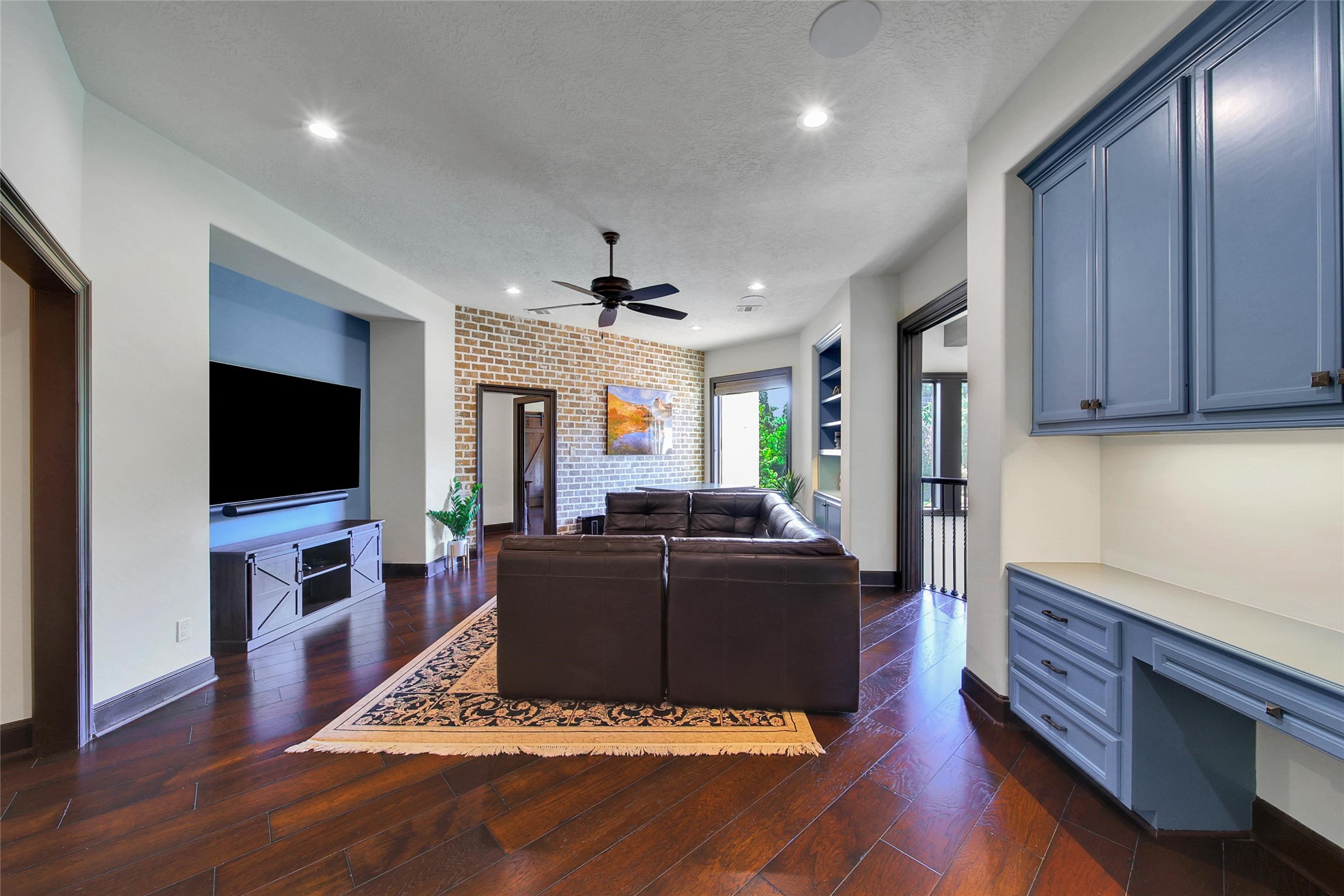 2 Highclere Park Drive Spring, TX 77379 - Photo 24 of 50 The upstairs game room offers a versatile space for play and relaxation. There's plenty of room for a sofa facing the entertainment nook, a table in front of the brick wall with built-in cabinetry—ideal for storing board games—and a built-in desk perfect for homework or a computer station.
