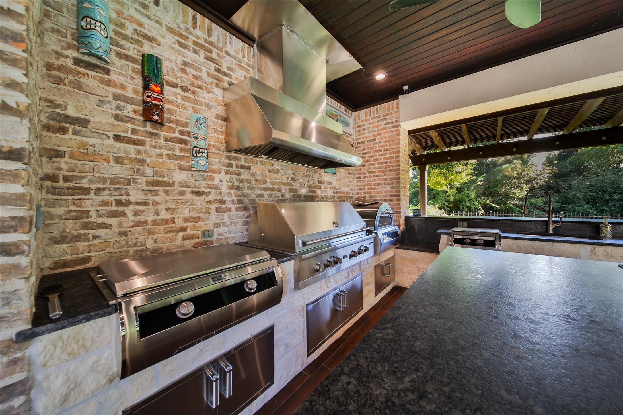 2 Highclere Park Drive Spring, TX 77379 - Photo 37 of 50 The outdoor kitchen is a chef’s dream, anchored by a Viking Professional Series grill and enhanced with recently added MagicChef appliances, including a flattop grill, pizza oven, oversized gas burner, fridge, and deep sink. Entertain with ease thanks to the built-in kegerator with dual beer taps—perfect for serving up drinks in style.
