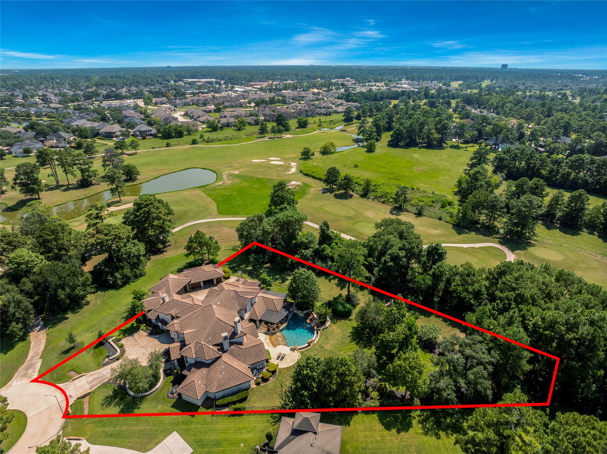 2 Highclere Park Drive Spring, TX 77379 - Photo 44 of 50 This expansive homesite offers ample space beyond the pool for outdoor activities and leisure. For added enjoyment, a basketball hoop is thoughtfully positioned by the golf cart bay and porte-cochere, blending recreation seamlessly with functionality.