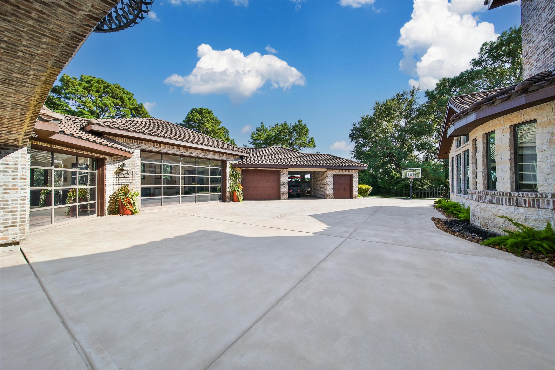 2 Highclere Park Drive Spring, TX 77379 - Photo 45 of 50 This gated motor court boasts a five-bay garage with a golf cart space, easy vehicle access, and extra parking. The adjacent porte cochere adds covered convenience and additional storage, blending functionality with elegance.